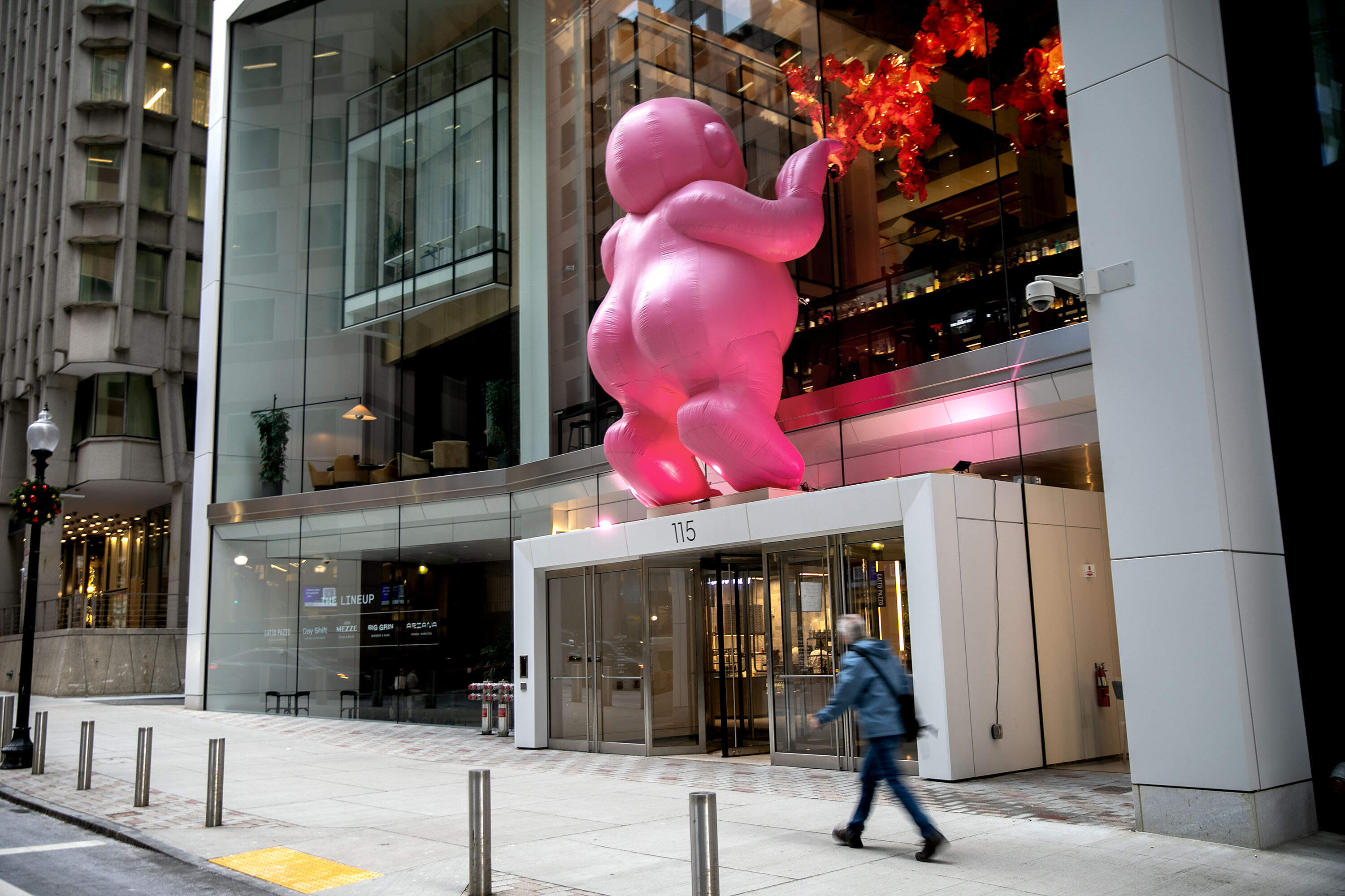 Mr. Pink, an inflatable sculpture by Philippe Katerine, peers into the Winthrop Center from Federal St. as part of the 2025 Winteractive exhibit in downtown Boston. (Robin Lubbock/WBUR)