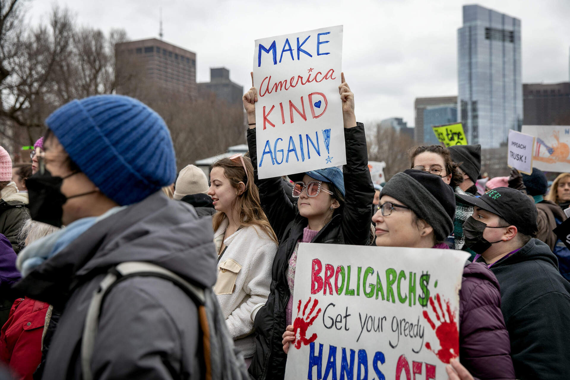 A group of protesters, many of them women, participated in the Boston People's March. Several held up signs on Boston Common. (Robin Lubbock/WBUR)