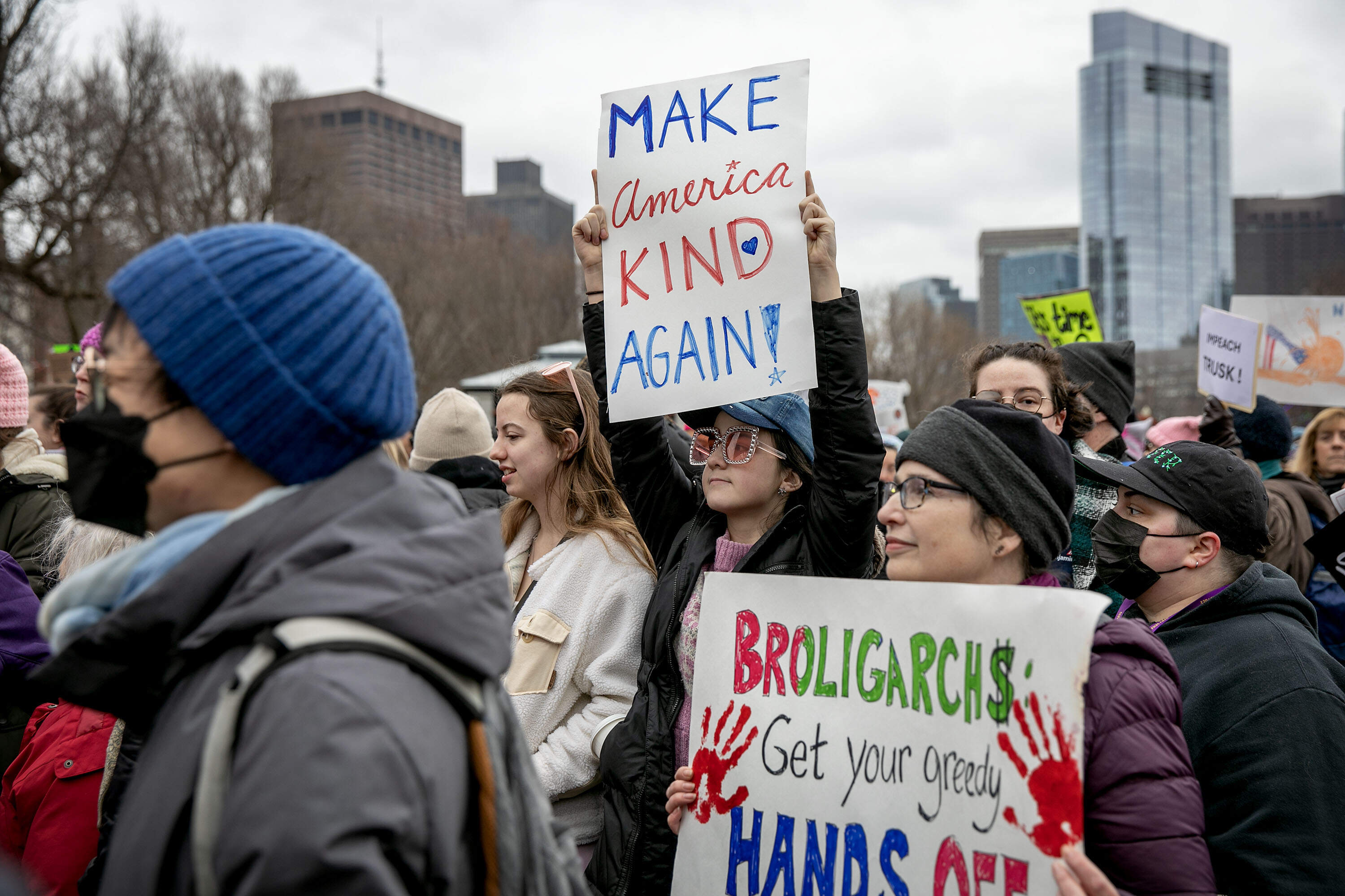 A group of protesters, many of them women, participated in the Boston People's March. Several held up signs on Boston Common. (Robin Lubbock/WBUR)