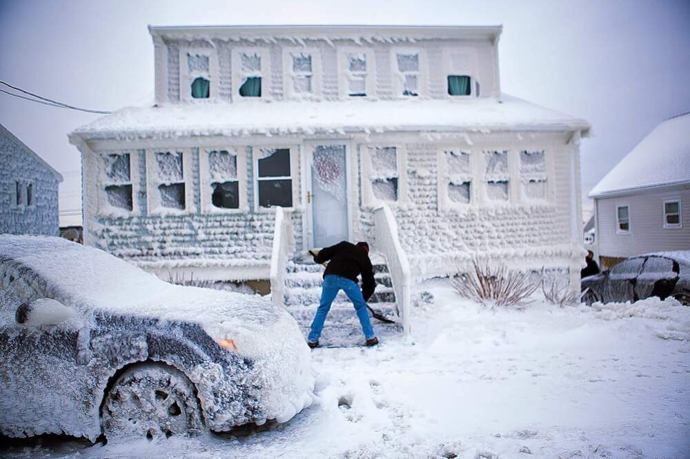 Paul Rugg digs out of his sea-sprayed house on Foster Street in the Brant Rock area of Marshfield, Mass., on Jan. 28, 2015. (Jesse Costa/WBUR)