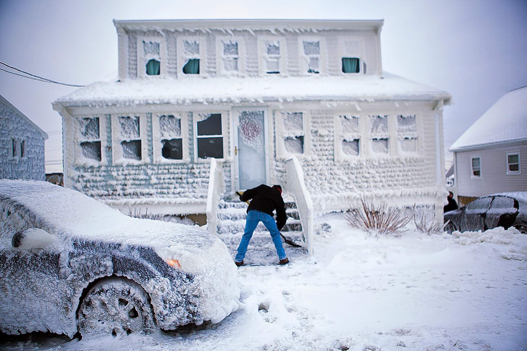 Paul Rugg digs out of his sea-sprayed house on Foster Street in the Brant Rock area of Marshfield, Mass., on Jan. 28, 2015. (Jesse Costa/WBUR)