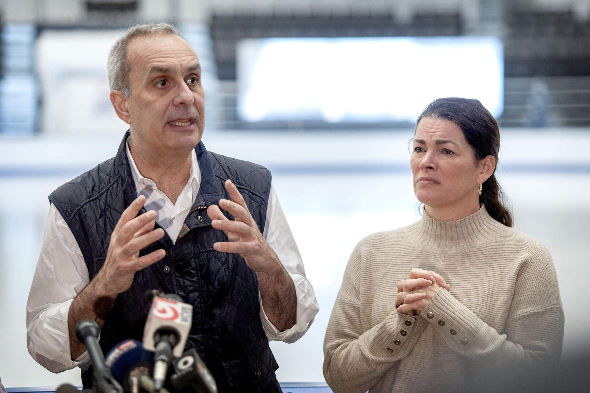 Doug Zeghibe, CEO of the Skating Club of Boston, and Olympian Nancy Kerrigan talk with reporters in Norwood on Thursday. (Robin Lubbock/WBUR)