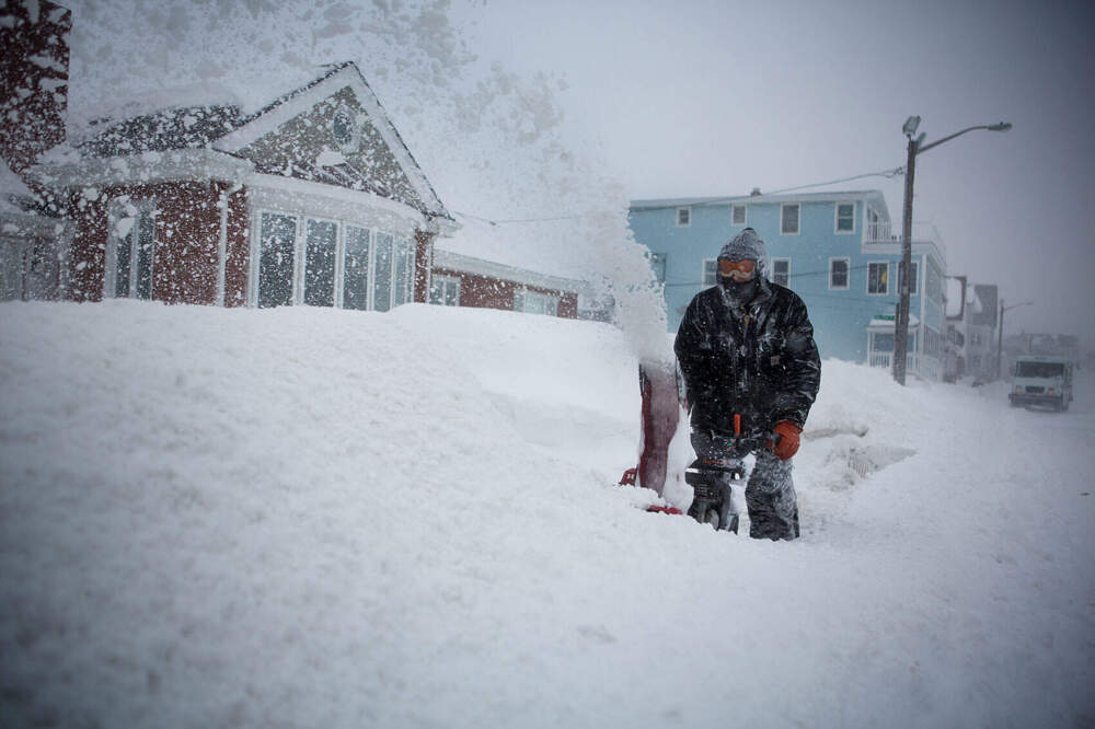 Sean Foley battles whiteout conditions while snow blowing his walkway in Winthrop. (Jesse Costa/WBUR)