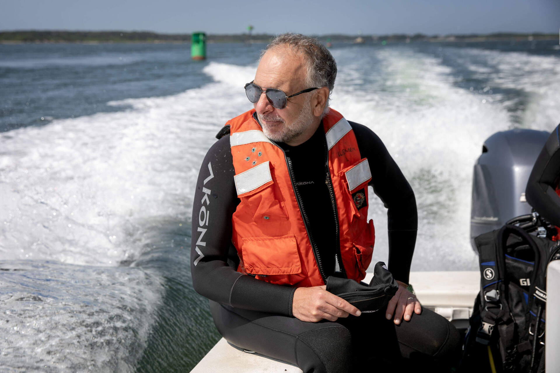 EPA marine biologist Phil Colarusso rides to an area of eelgrass beds near Woods Hole, Mass. (Robin Lubbock/WBUR)