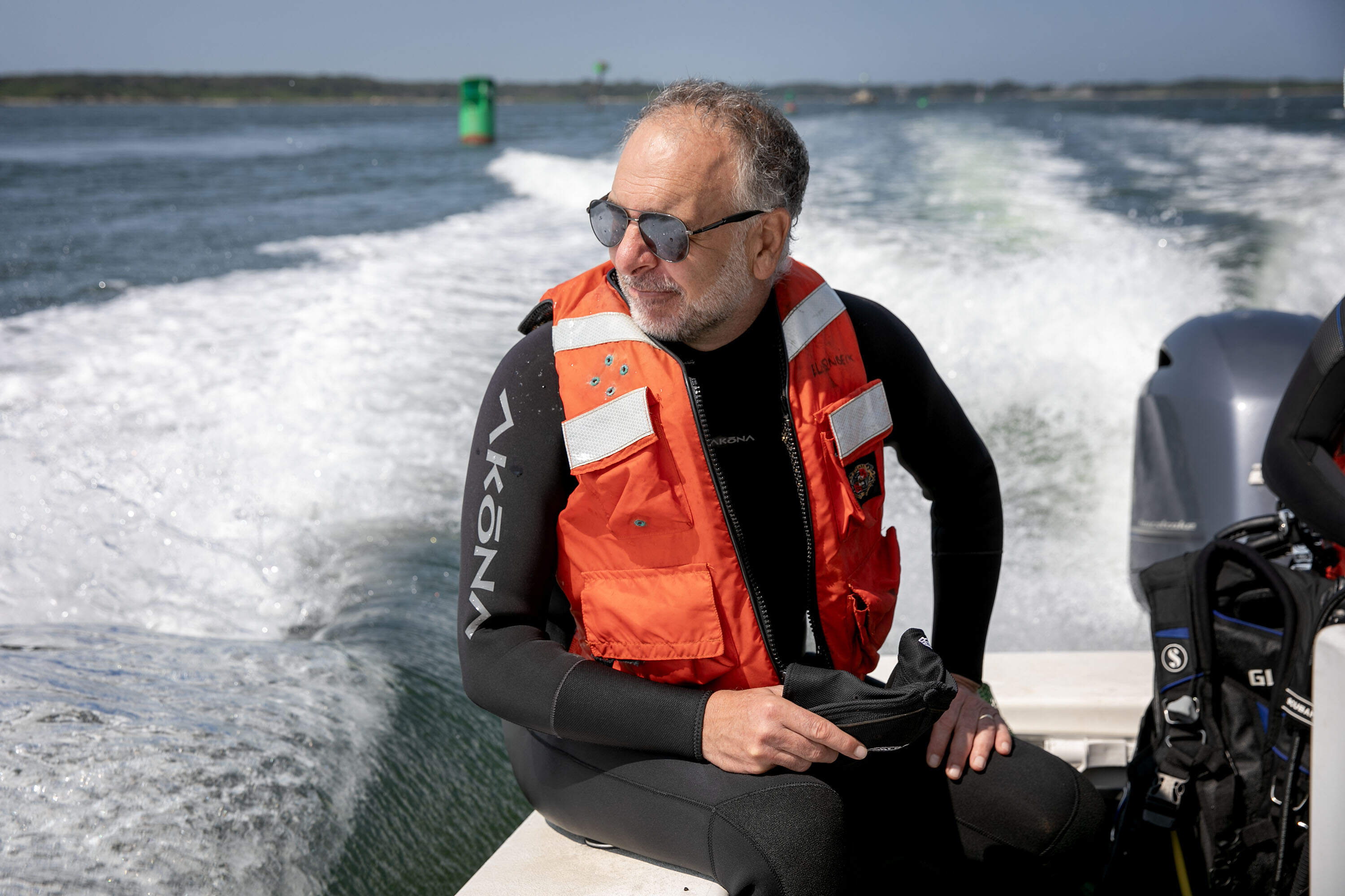 EPA marine biologist Phil Colarusso rides to an area of eelgrass beds near Woods Hole, Mass. (Robin Lubbock/WBUR)