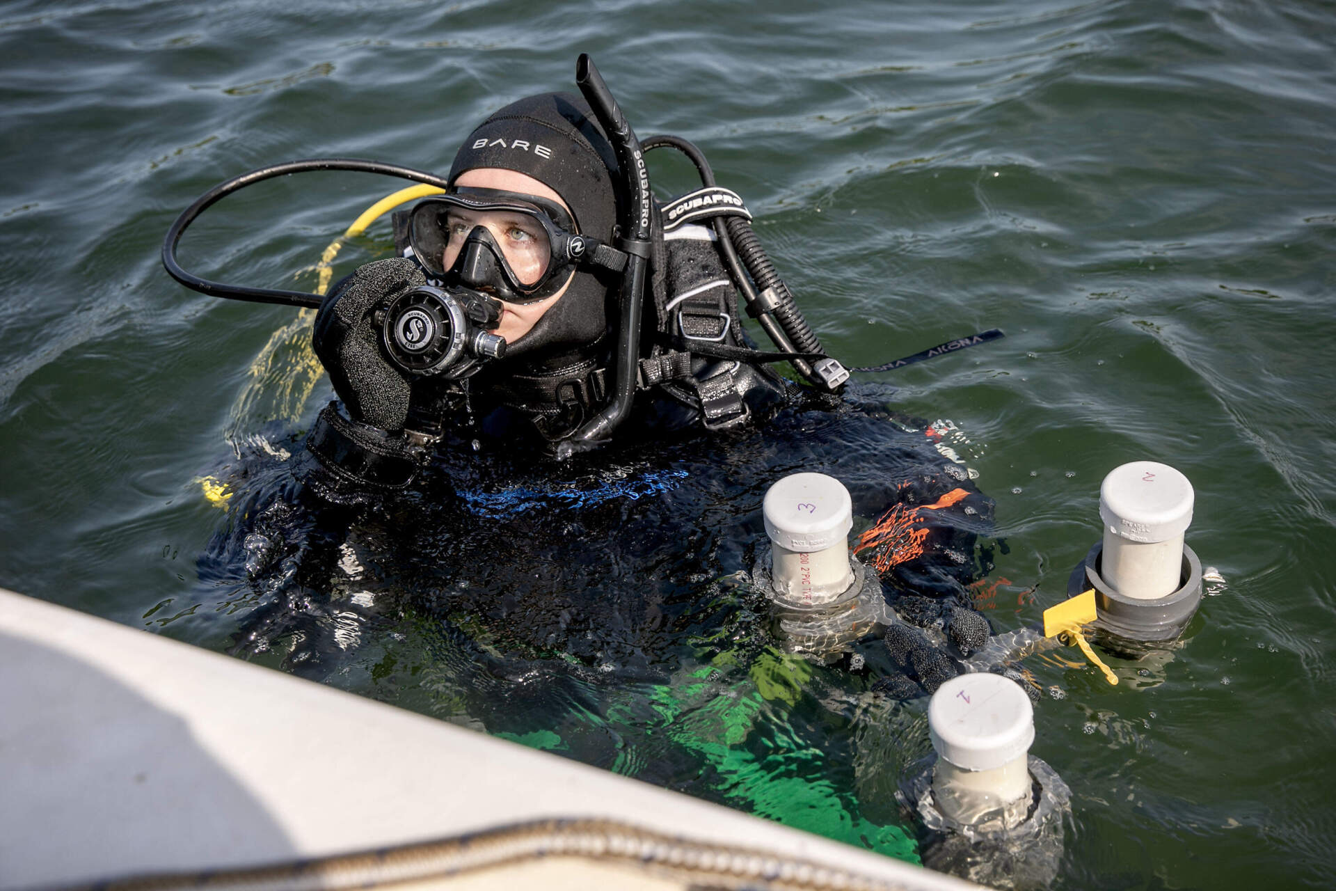 EPA scientist and diver Evelyn Spencer leaves the dive boat with a sediment trap to place in the eelgrass bed. (Robin Lubbock/WBUR)