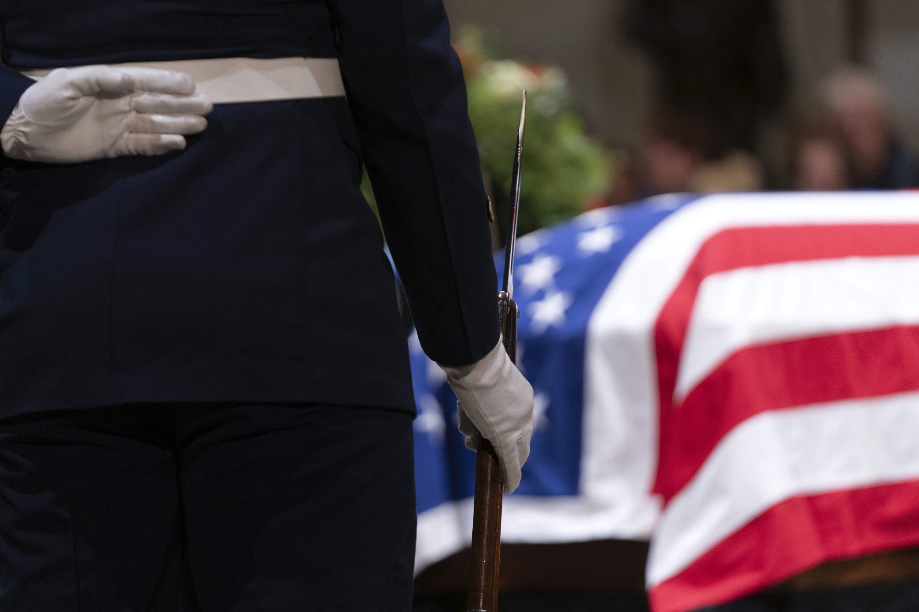 Honor Guard service members look at the flag-draped casket of former President Jimmy Carter as he lies in state in the Capitol, Tuesday, Jan. 7, in Washington. Carter died Dec. 29 at the age of 100. (Jose Luis Magana/AP)