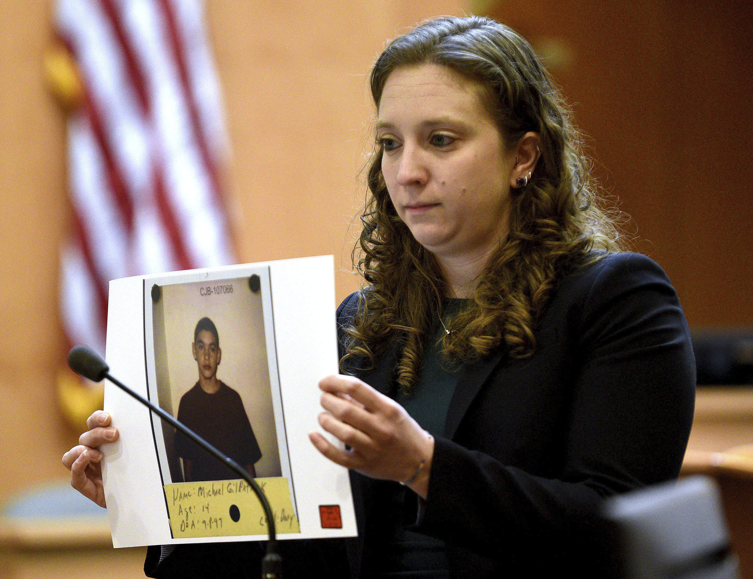 Assistant Attorney General Audriana Mekula shows the jury Michael Gilpatrick's intake photograph when he was 14 years old during the first day of the Stephen Murphy trial at Hillsborough County Superior Court in Manchester, N.H., on Wednesday, Jan. 15. (David Lane/Union Leader, pool via AP)