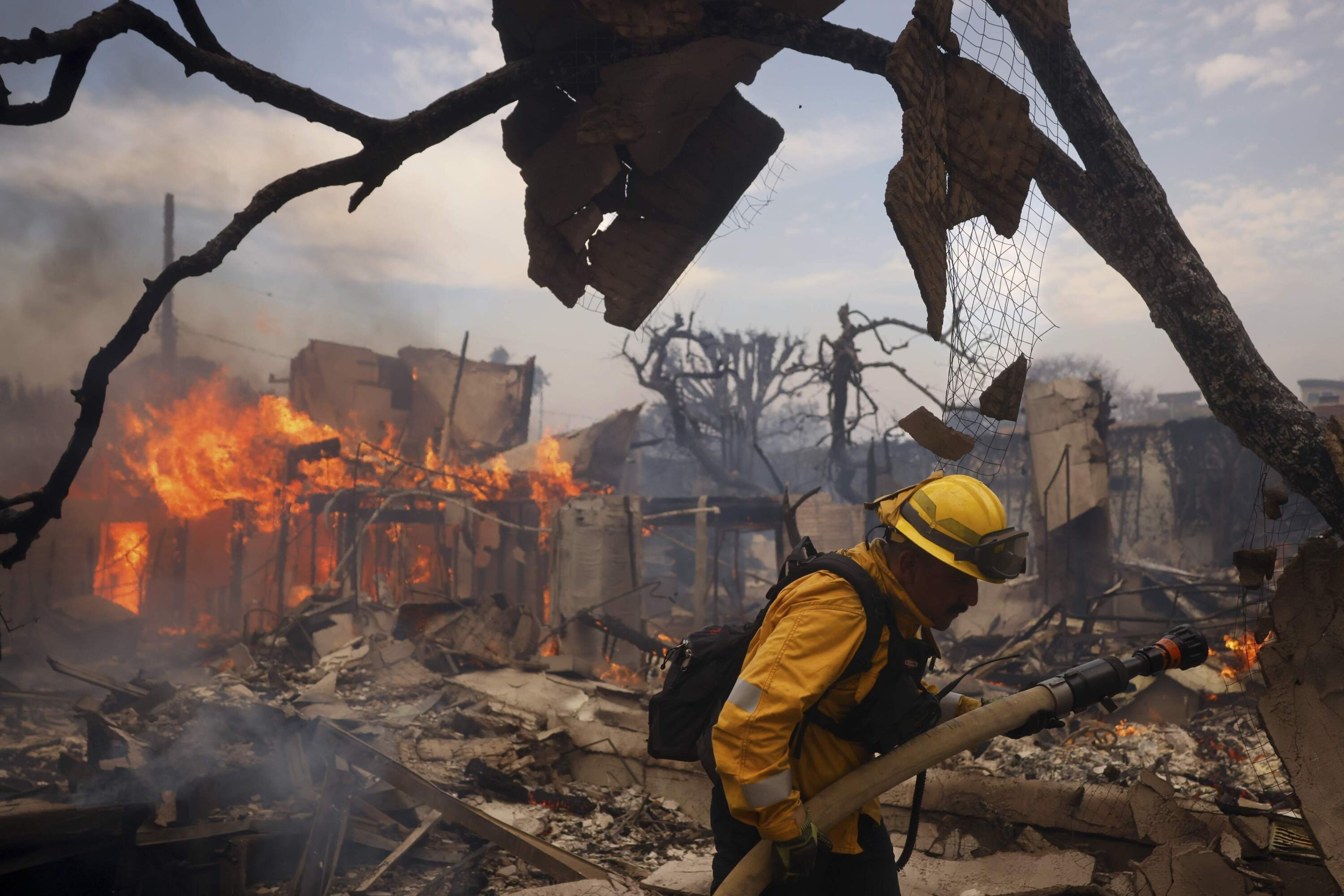 A firefighter battles the Palisades Fire around a burned structure in the Pacific Palisades neighborhood of Los Angeles, Jan. 8, 2025. (Etienne Laurent/AP)