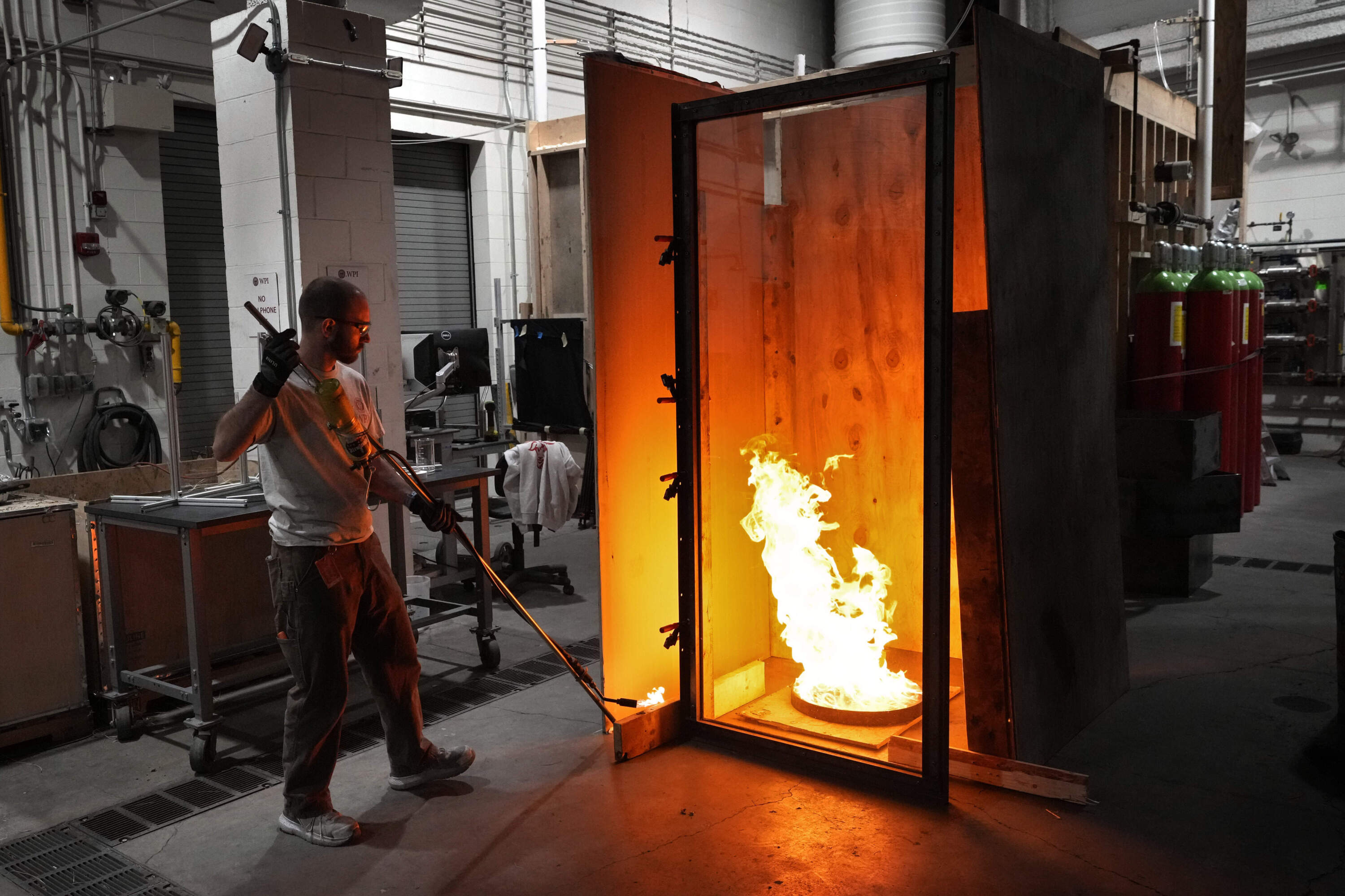 Fritz Brokaw, lab manager in the department of Fire Protection Engineering at Worcester Polytechnic Institute, ignites a test fire, Wednesday, Jan. 15, 2025, in Worcester, Mass. (AP Photo/Robert F. Bukaty)