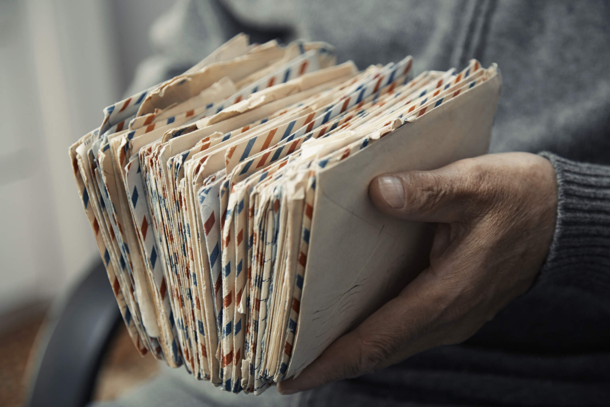 A man holds a stack of old aerogrammes. (Getty Images)