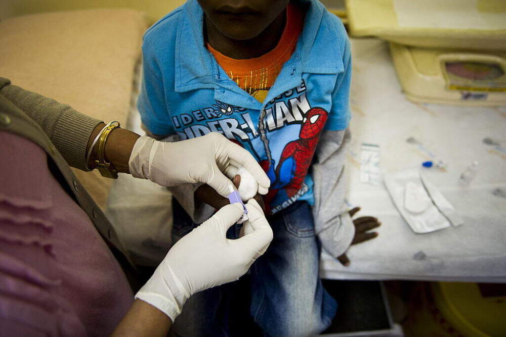 Sally Naidoo administers an HIV test on a young boy at the Right To Care AIDS clinic on January 27, 2012 in Johannesburg, South Africa. The non-governmental organisation has, with US funding from PEPFAR to revived their AIDS clinic. (Foto24/Gallo Images via Getty Images)