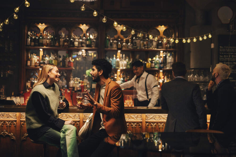 Customers enjoying drinks near a bar counter. (Maskot/Getty Images)