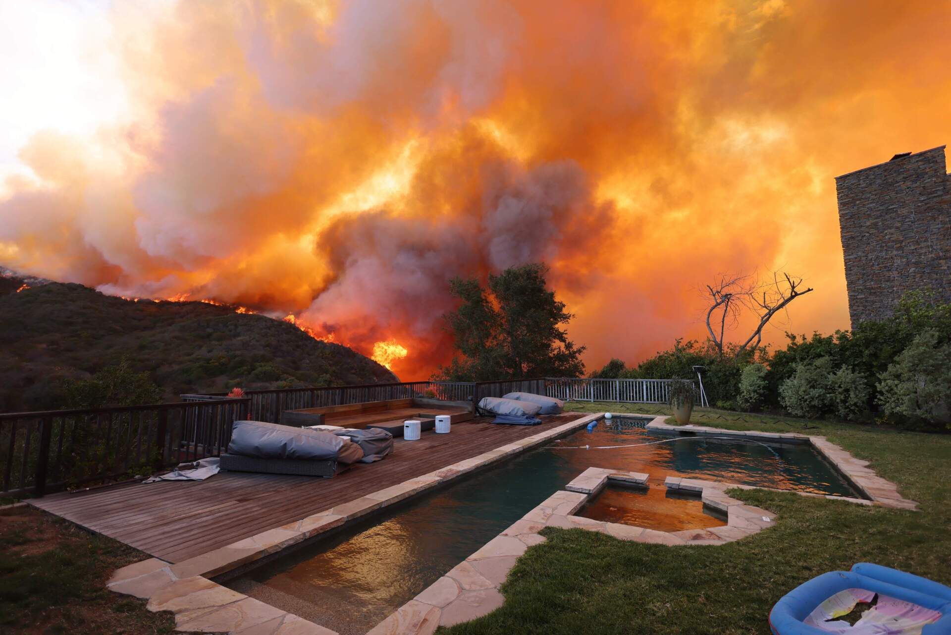 A brush fire burns near homes in Pacific Palisades, California on Tuesday. (David Swanson/AFP via Getty)