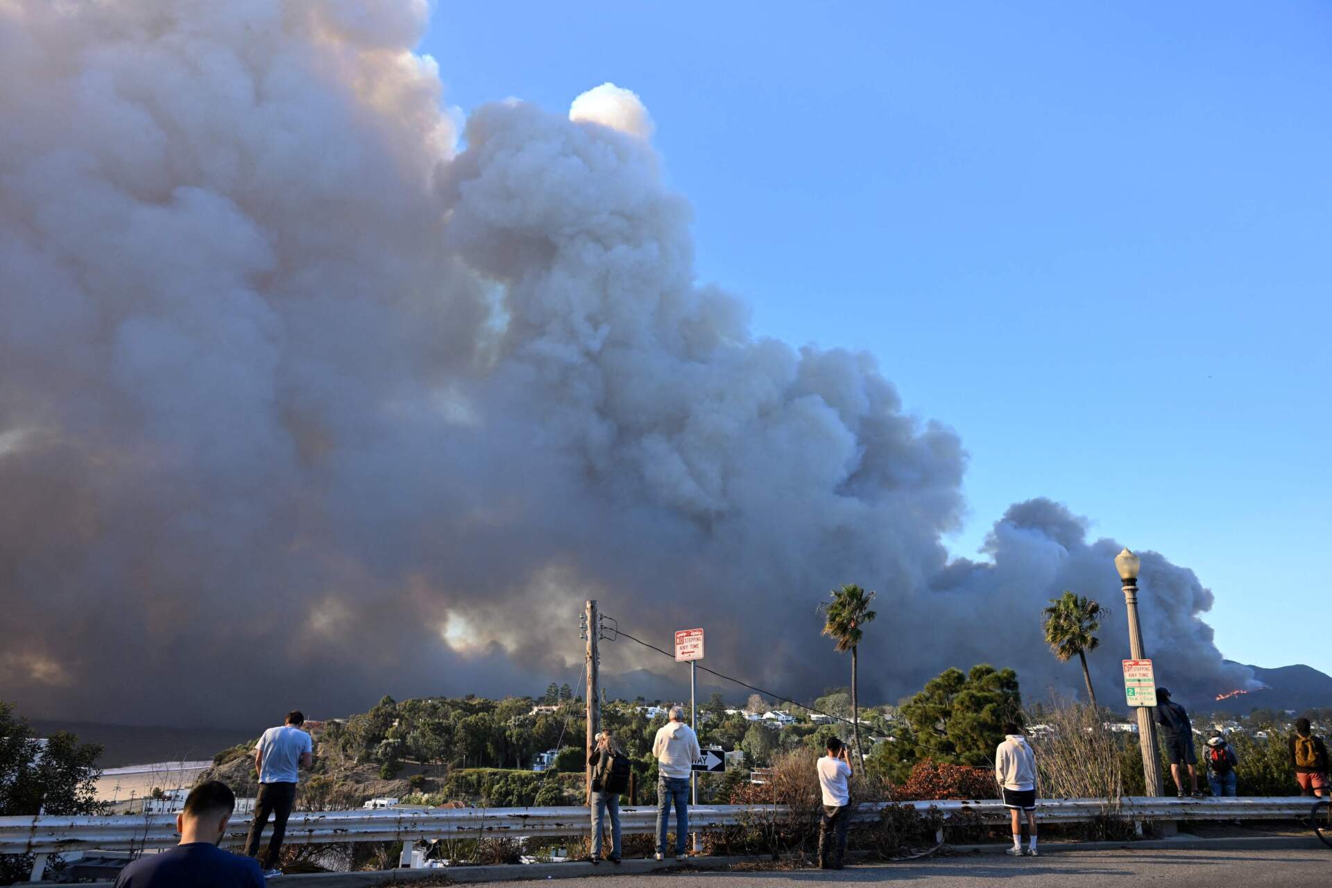 People watch smoke from the Palisades Fire from Santa Monica on Tuesday. (Robyn Beck/AFP via Getty)