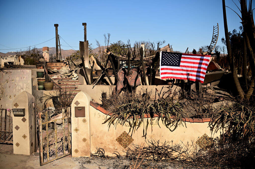 The American flag hangs in the front of a home destroyed by the Palisades Fire in Los Angeles on Jan. 13. (Agustin Paullier/AFP via Getty Images)