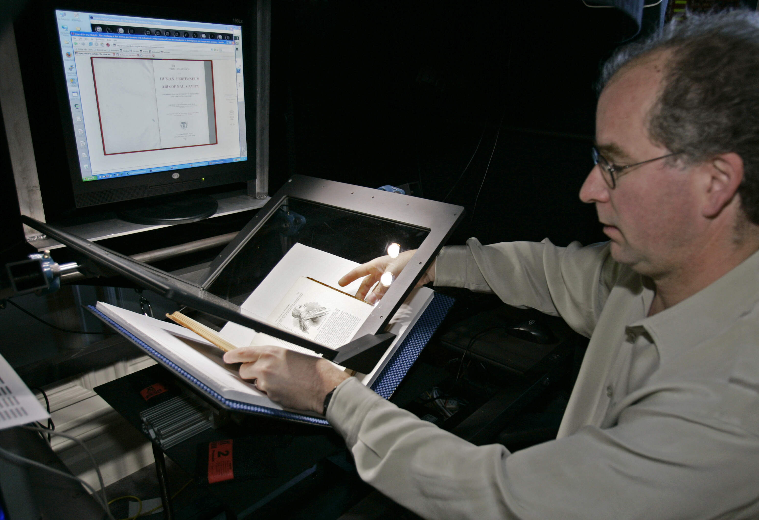 FILE-On this Monday, Dec. 18, 2006, file photo, Internet Archive founder Brewster Kahle prepares a book for digital scanning in San Francisco. Google and U.S. publishers settled a longstanding dispute over Google's book-scanning project Thursday, Oct. 4, 2012. Google already has scanned more than 20 million books. Publishers and authors sued, saying the project violated their copyrights. (AP Photo/Ben Margot)