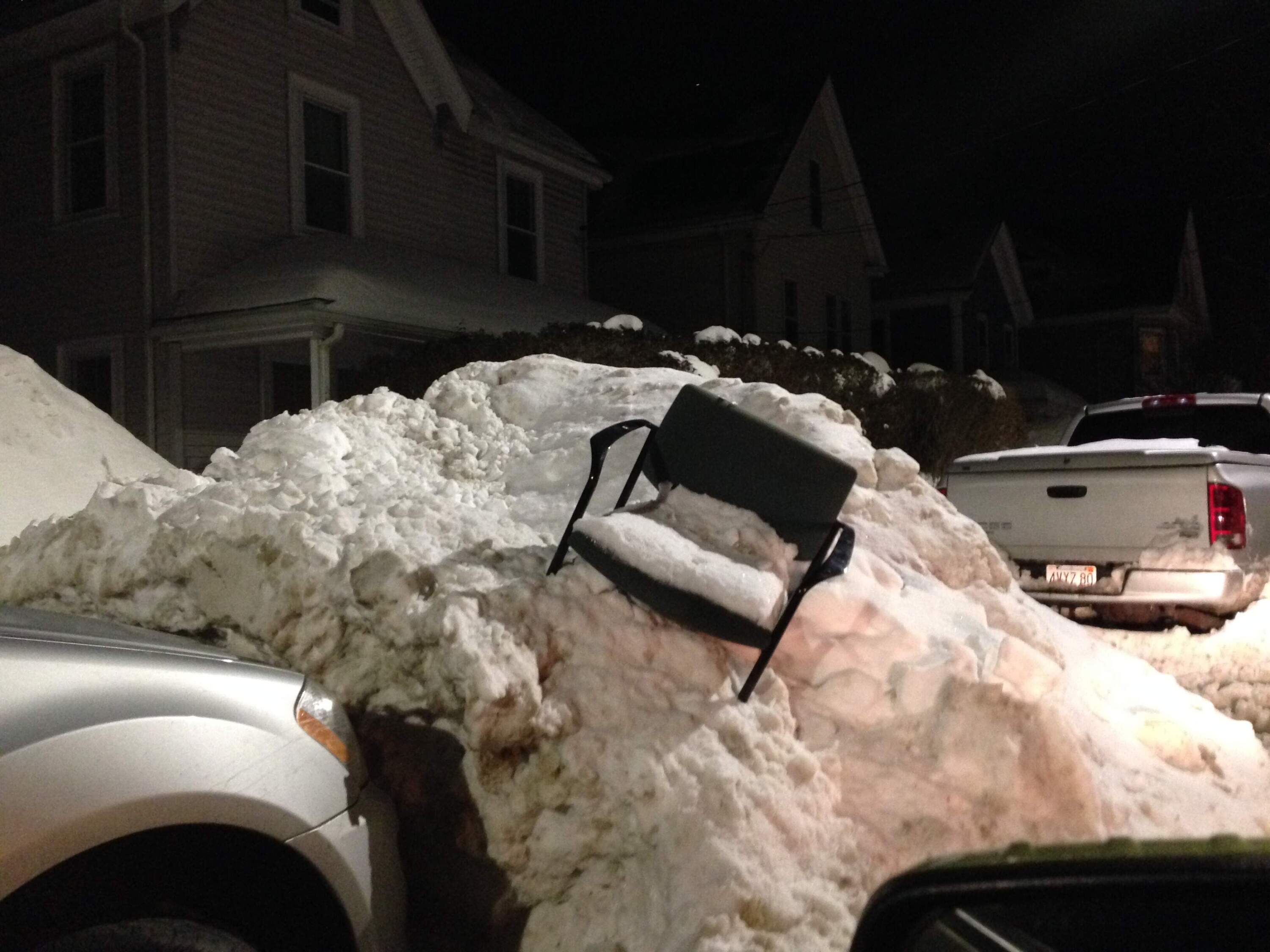 A chair sits abandoned on top of a snow bank. (Beth Healy/WBUR)