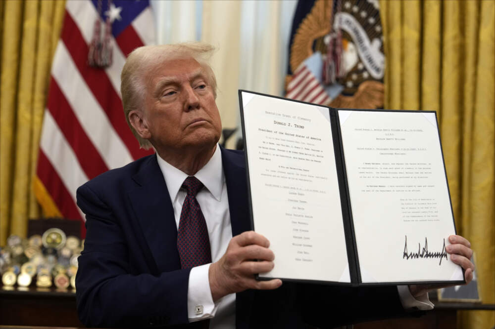 President Donald Trump holding up a order for clemency for anti-abortion protesters as he signs executive orders in the Oval Office of the White House, Thursday, Jan. 23, 2025, in Washington. (Ben Curtis/AP)