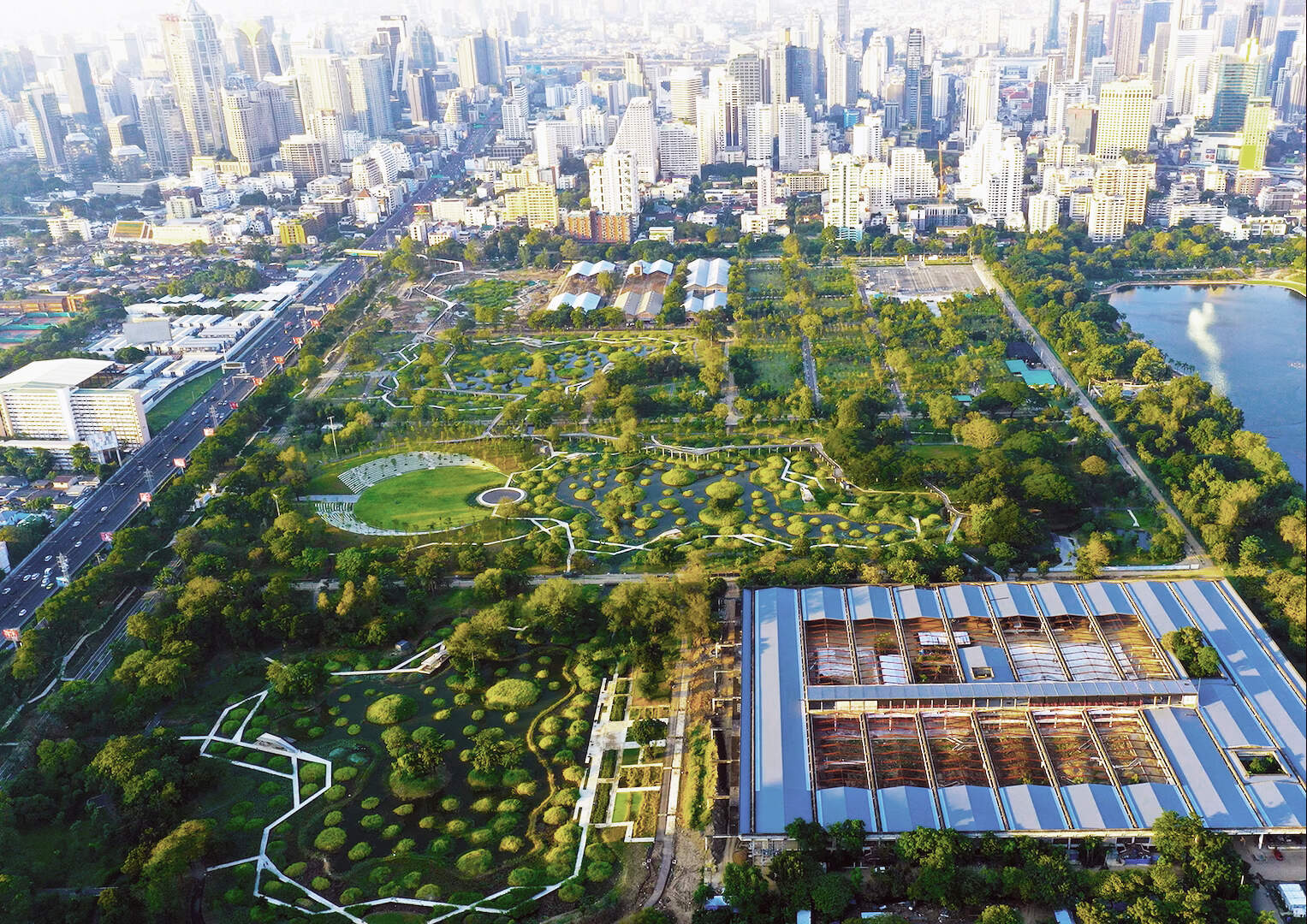 Benjakitti Forest Park in Bangkok, Thailand, showcasing a lush green space with water features and walking paths.