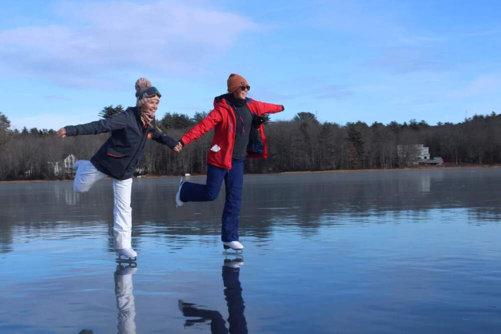 Marina Gray, left, and Danielle Duperry try out some moves on Highland Lake on Wednesday, Jan. 8. (Ari Snider/Maine Public)