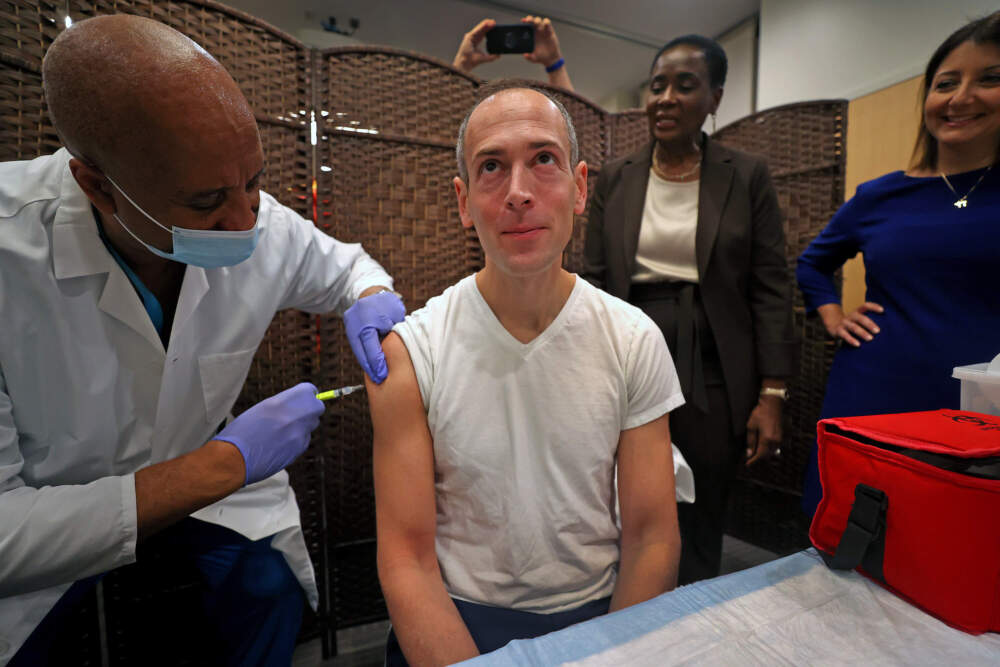 Robbie Goldstein, Massachusetts Commissioner of Public Health, gets a flu shot at Whittier Street Health Center in 2023. Dr. Stephen Wright, medical director at Whittier Street, administers the shot. (David L. Ryan/The Boston Globe via Getty Images)