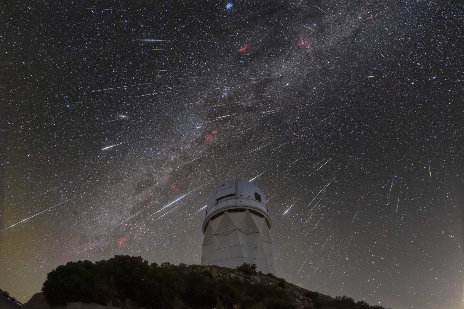 In this Dec. 14, 2023 photo provided by NOIRLab, meteors from the Geminid meteor shower streak across the sky above the Nicholas U. Mayall Telescope at Kitt Peak National Observatory, a program of the National Science Foundation's NOIRLab, about 56 miles southwest of Tucson in the Tohono O'odham Nation. (NSF/NOIRLab via AP file photo)