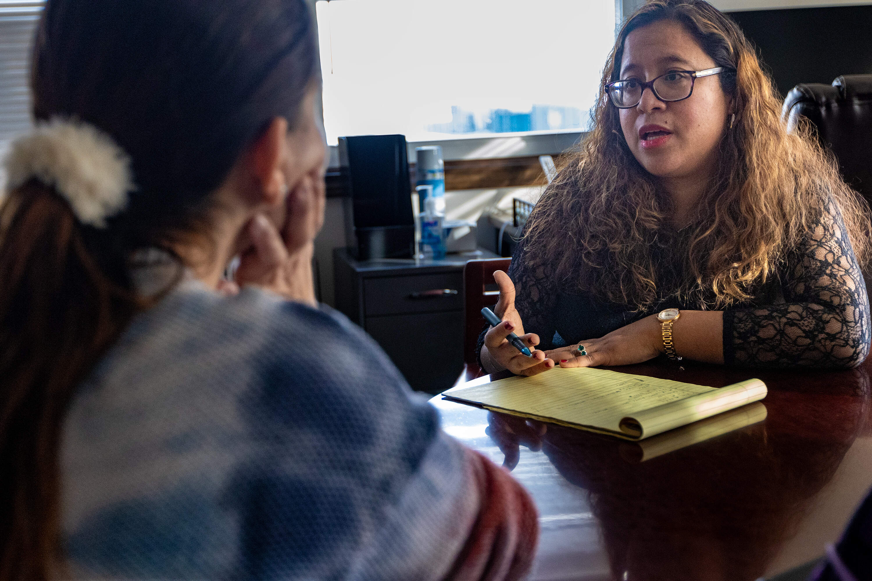 Immigration attorney Jennifer Velarde advises a prospective client at her office in New Bedford. (Jesse Costa/WBUR)