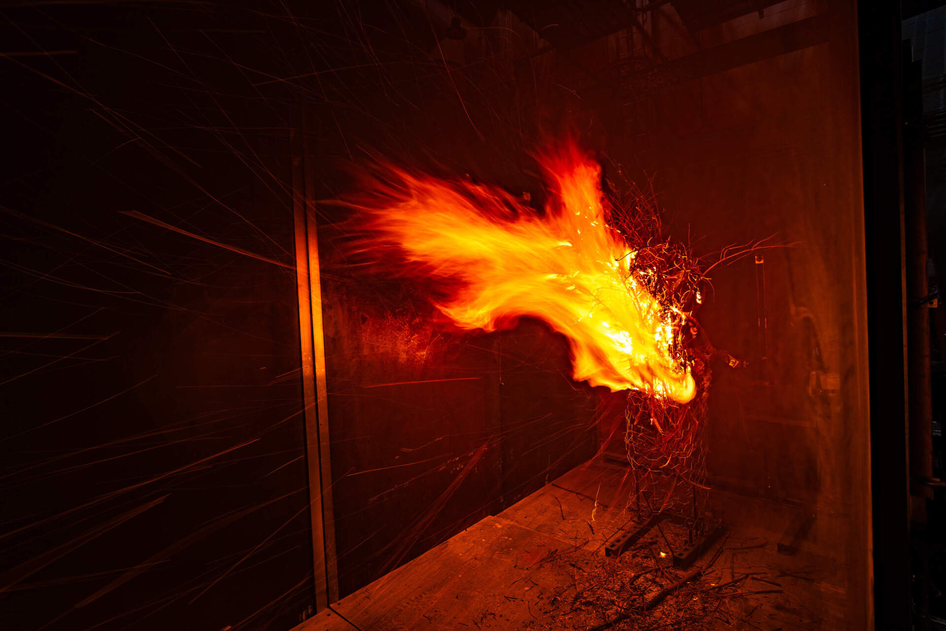Burning embers fly inside the wind tunnel at the UL Fire Protection Engineering Performance Lab at WPI in Worcester. (Jesse Costa/WBUR)