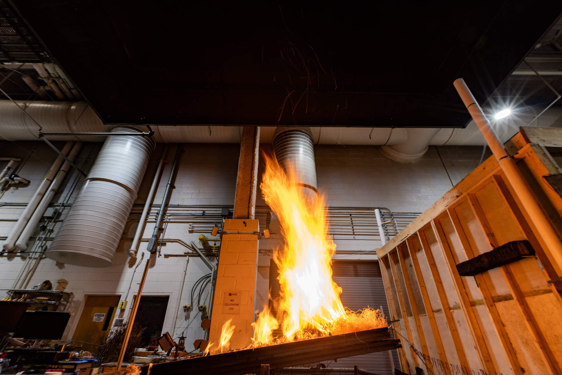 Fire leaps from the tilted table where fire protection engineering students are conducting a test to see how a burning fire reacts to an incline. (Jesse Costa/WBUR)
