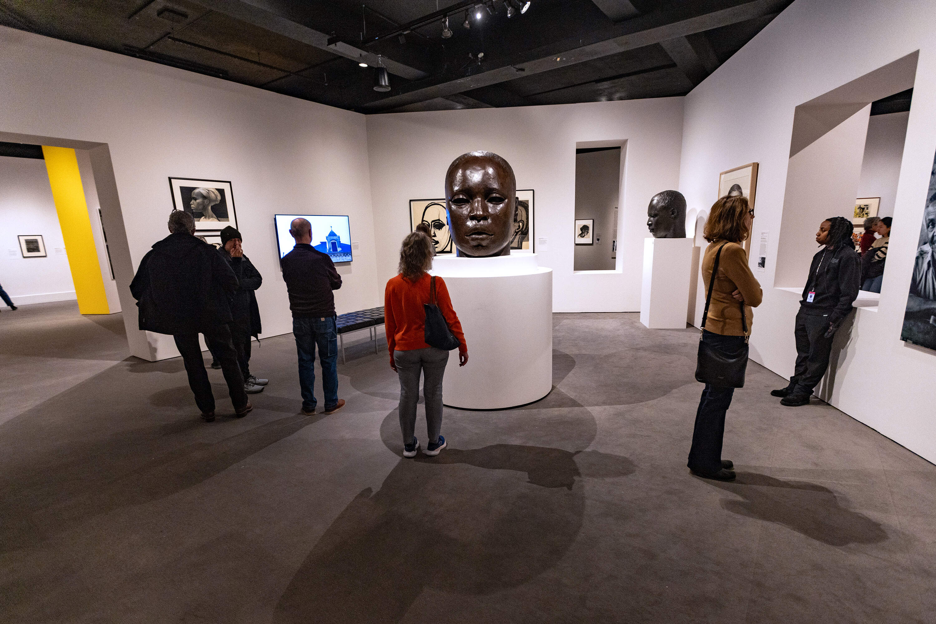 Museum patrons look at a half-size maquette of “Eternal Presence,” at the “Witnessing Humanity: The Art of John Wilson” exhibit at the Museum of Fine Arts, Boston. The actual statue is seven feet tall and stands on the grounds of the National Center of Afro-American Artists in Roxbury. (Jesse Costa/WBUR)