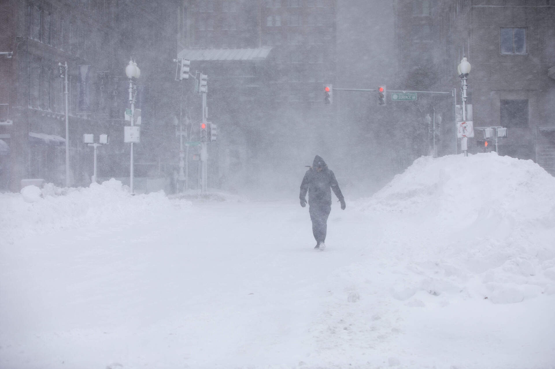 A pedestrian walks through wind and snow blowing along Atlantic Avenue in Boston during the blizzard of 2026. (Robin Lubbock/WBUR)