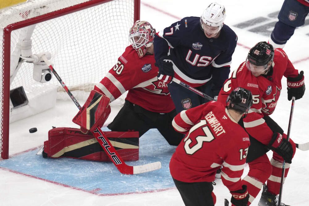 Canada goalie Jordan Binnington, left, looks back at the puck on a goal by United States' Jake Sanderson during the second period. (Charles Krupa/AP)