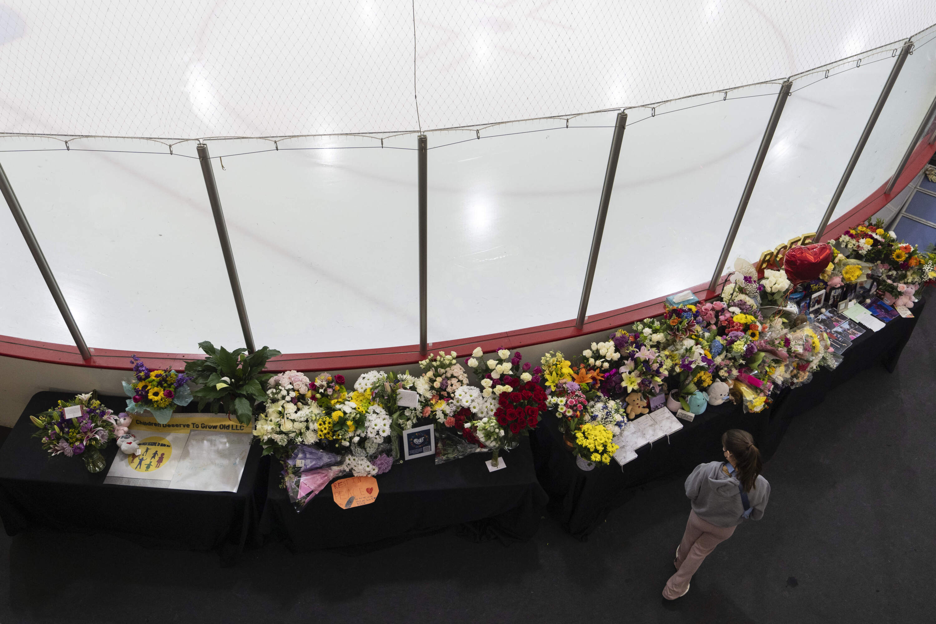 A memorial is seen along the boards at MedStar Capitals Iceplex Sunday, Feb. 2, in Arlington, Va., for the figure skaters who were among the 67 victims of a mid-air collision between an Army helicopter and an American Airlines flight from Kansas. (Carolyn Kaster/AP)