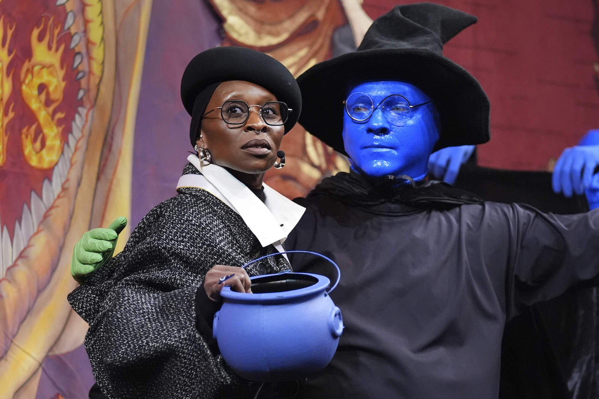 A member of the Blue Man Group dressed in a witch hat and cape awkwardly walked onstage to present Erivo with a blue pudding pot. (AP Photo/Charles Krupa)
