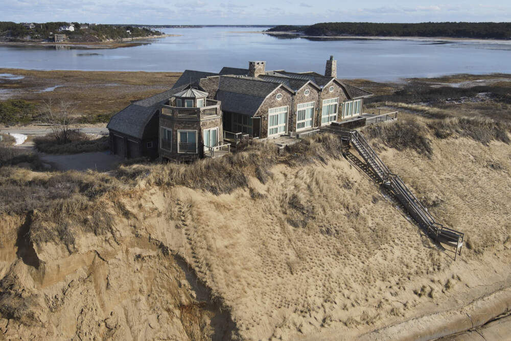 A home at risk of collapse is balanced on the dune overlooking Cape Cod Bay, Feb. 2, 2022. (Andre Muggiati/AP)