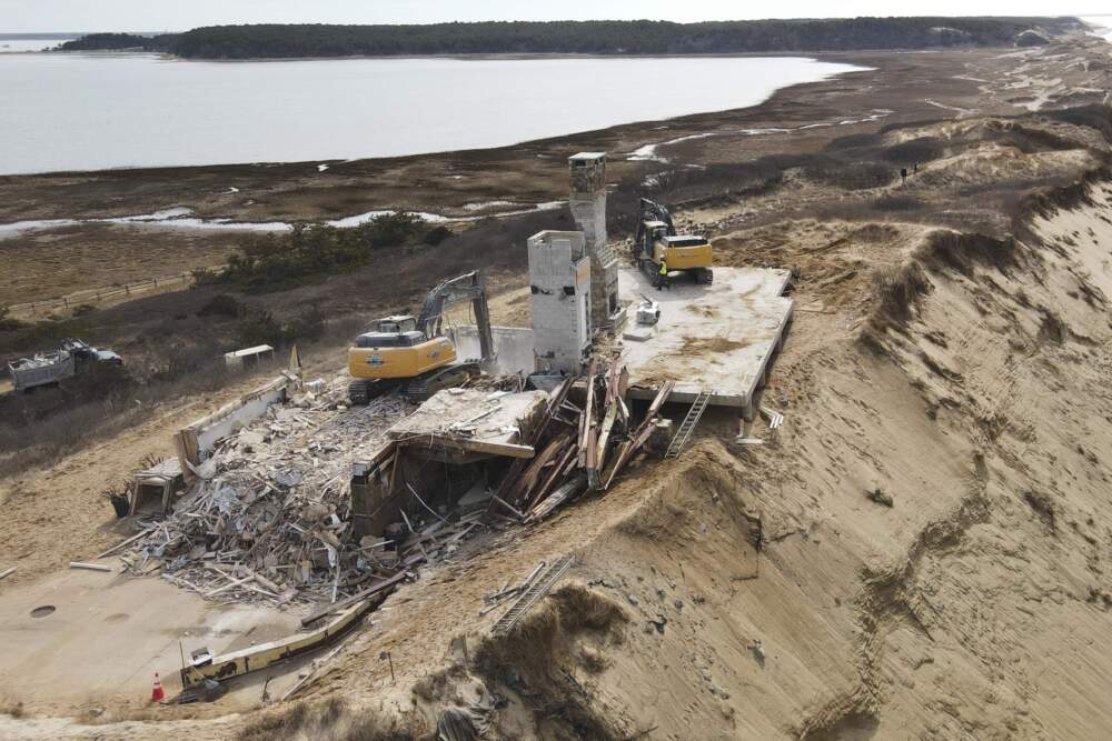 The remains of a home sit atop of a sandy bluff overlooking a beach in Wellfleet, Mass., Tuesday, Feb. 25, 2025. (Andre Muggiati/AP)