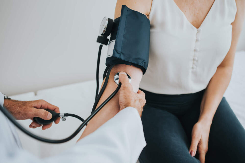 A health care professional takes a patient's blood pressure. (Getty Images)