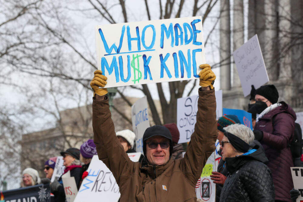 Protesters hold placards during a 50501 protest outside of the state capitol in Harrisburg, Penn. (Paul Weaver/SOPA Images/LightRocket via Getty Images)