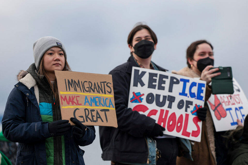 People hold signs during a march against Immigration and Customs Enforcement (ICE) entitled "Get our Gente Out of Guantanamo Bay!" in Seattle, Washington, on February 8, 2025. (Jason Redmond / AFP via Getty Images)