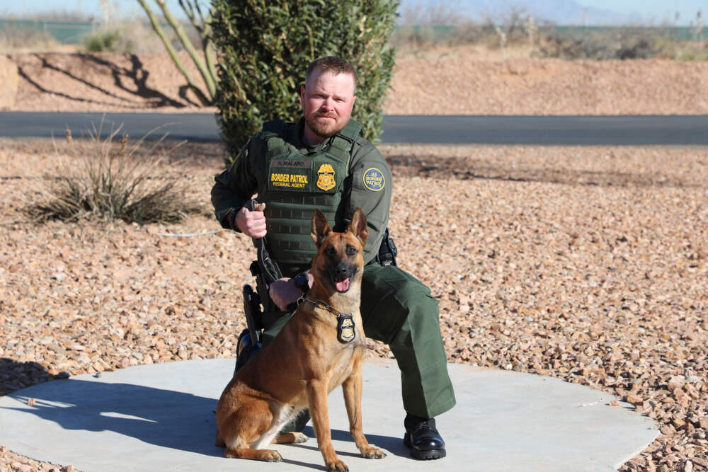 This undated and unknown location photo released by the Department of Homeland Security shows Border Patrol Agent David Maland posing with a service dog. (Department of Homeland Security via AP)