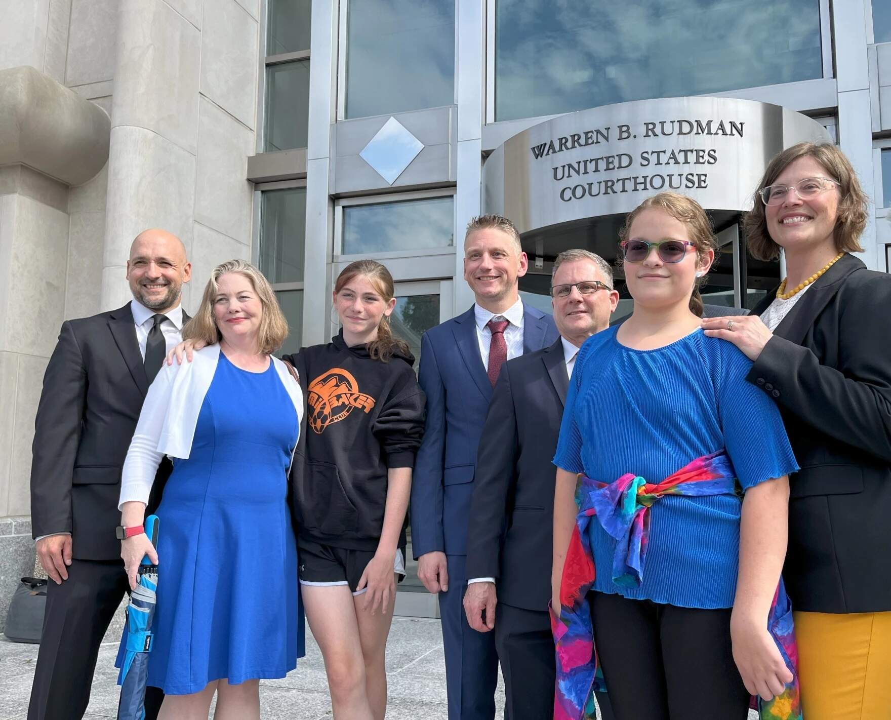 Parker Tirrell (third from left) and Iris Turmelle (second from right) gather outside the federal courthouse in Concord on Aug. 19, 2024 after a judge granted a temporary order allowing Tirrell to play for her school's soccer team. (Paul Cuno-Booth/NHPR)