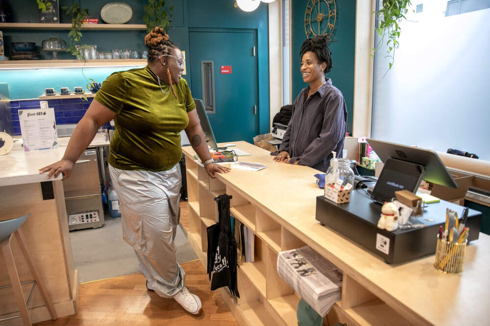 Founder Porsha Olayiwola chats with bookstore manager Franchie Viaud at JustBook-ish, in Fields Corner, Boston. (Robin Lubbock/WBUR)
