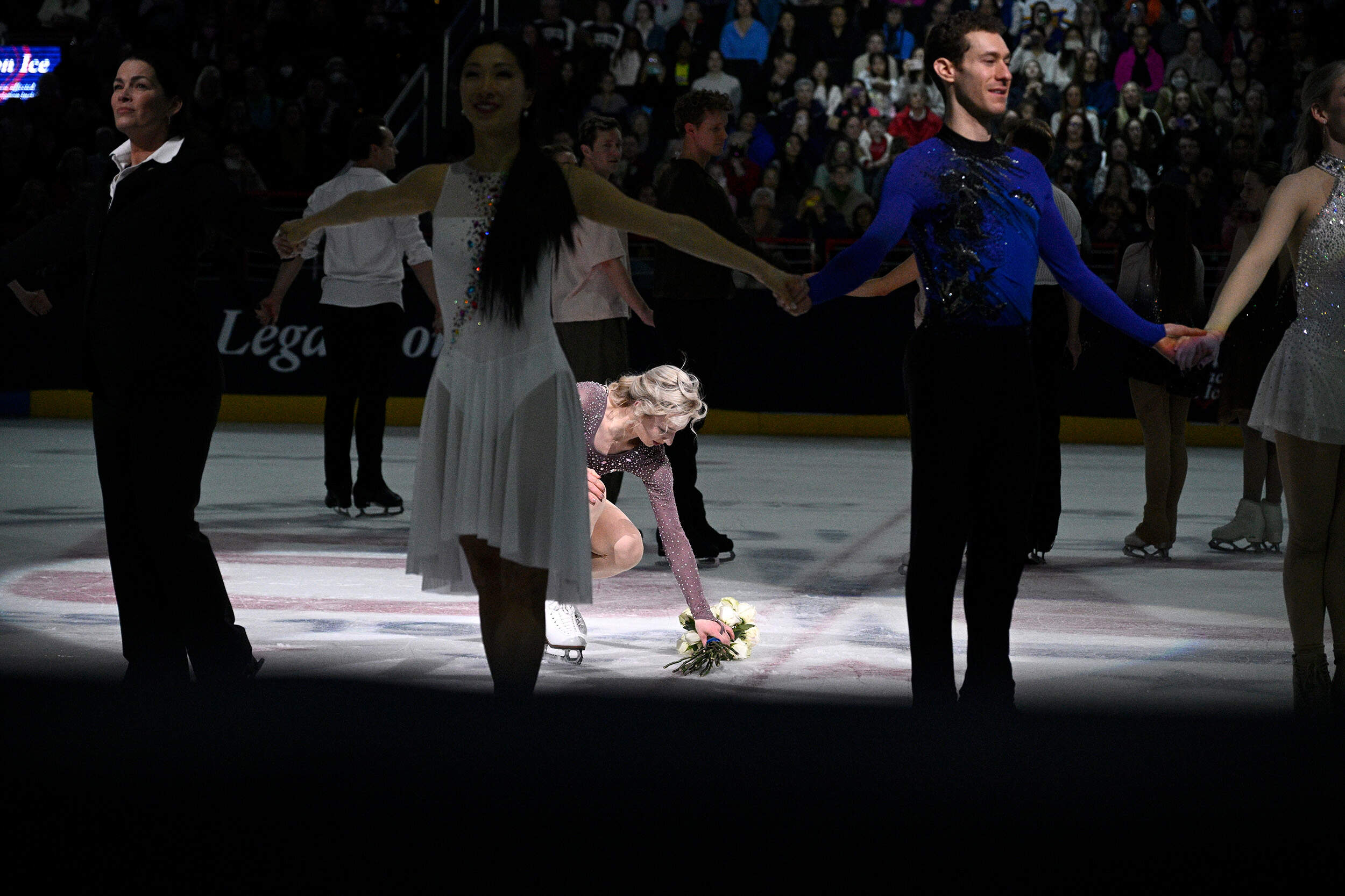 A skater places flowers on the ice in Washington, at the Legacy on Ice event. (Nick Wass/AP)