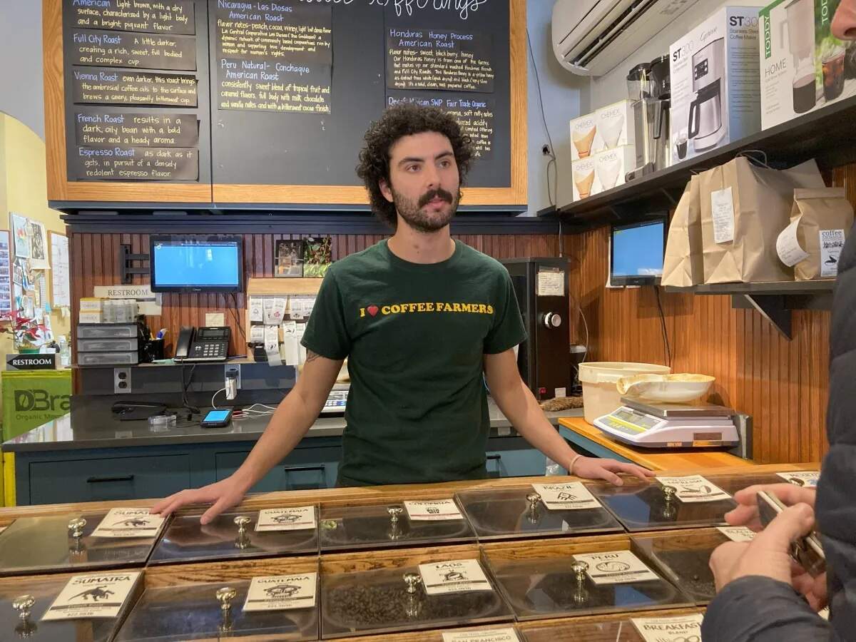 Eddie Cascella, 26, who holds an M.A. in Environmental Science and Management from URI, working at the Coffee Exchange in Providence. (Lynn Arditi/The Public's Radio)