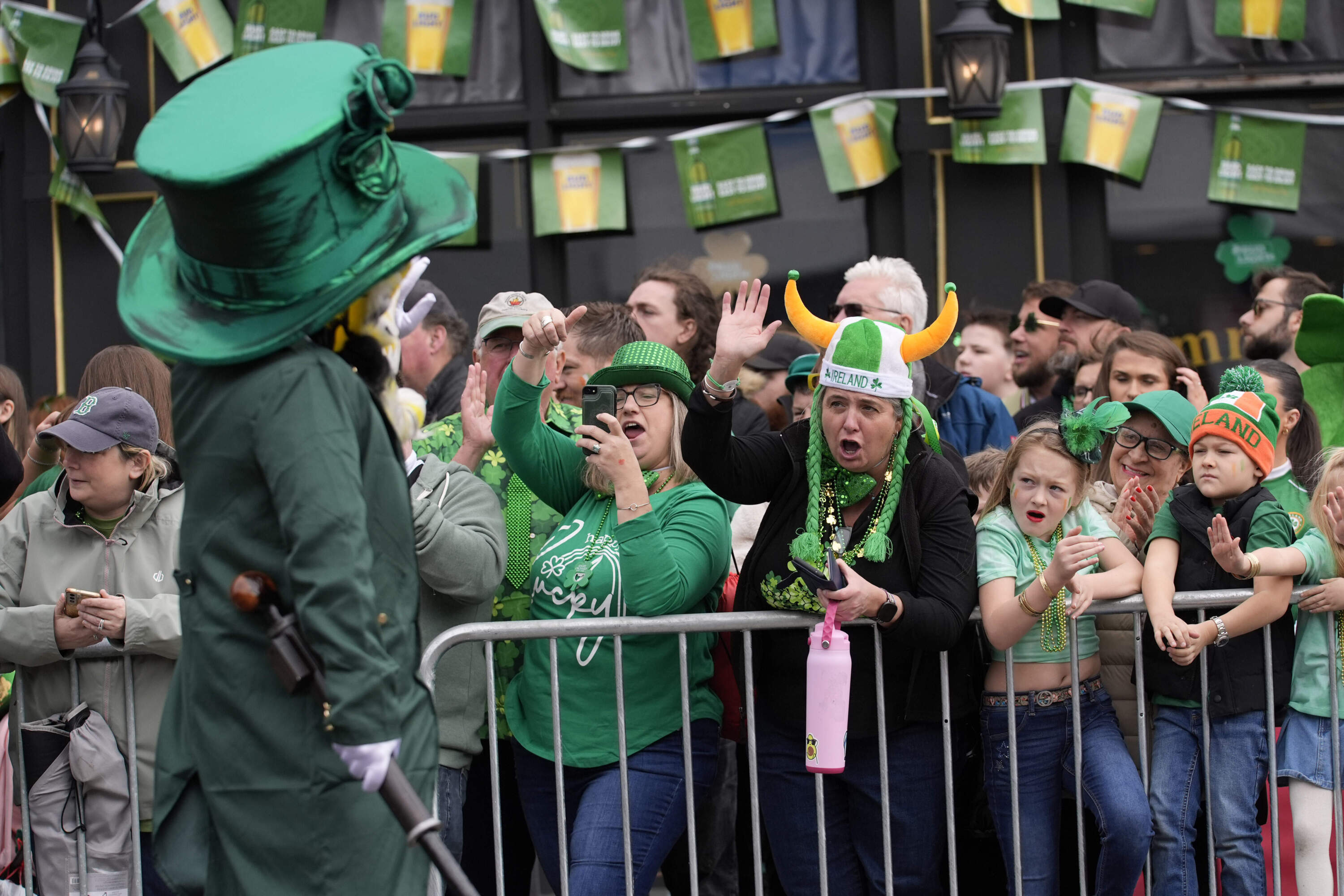 Michele Hunter, of Pawlet, Vt., center left, and Erin Riley, of Saugus, Mass., cheer a performer at the St. Patrick's Day parade. (Robert F. Bukaty/AP)