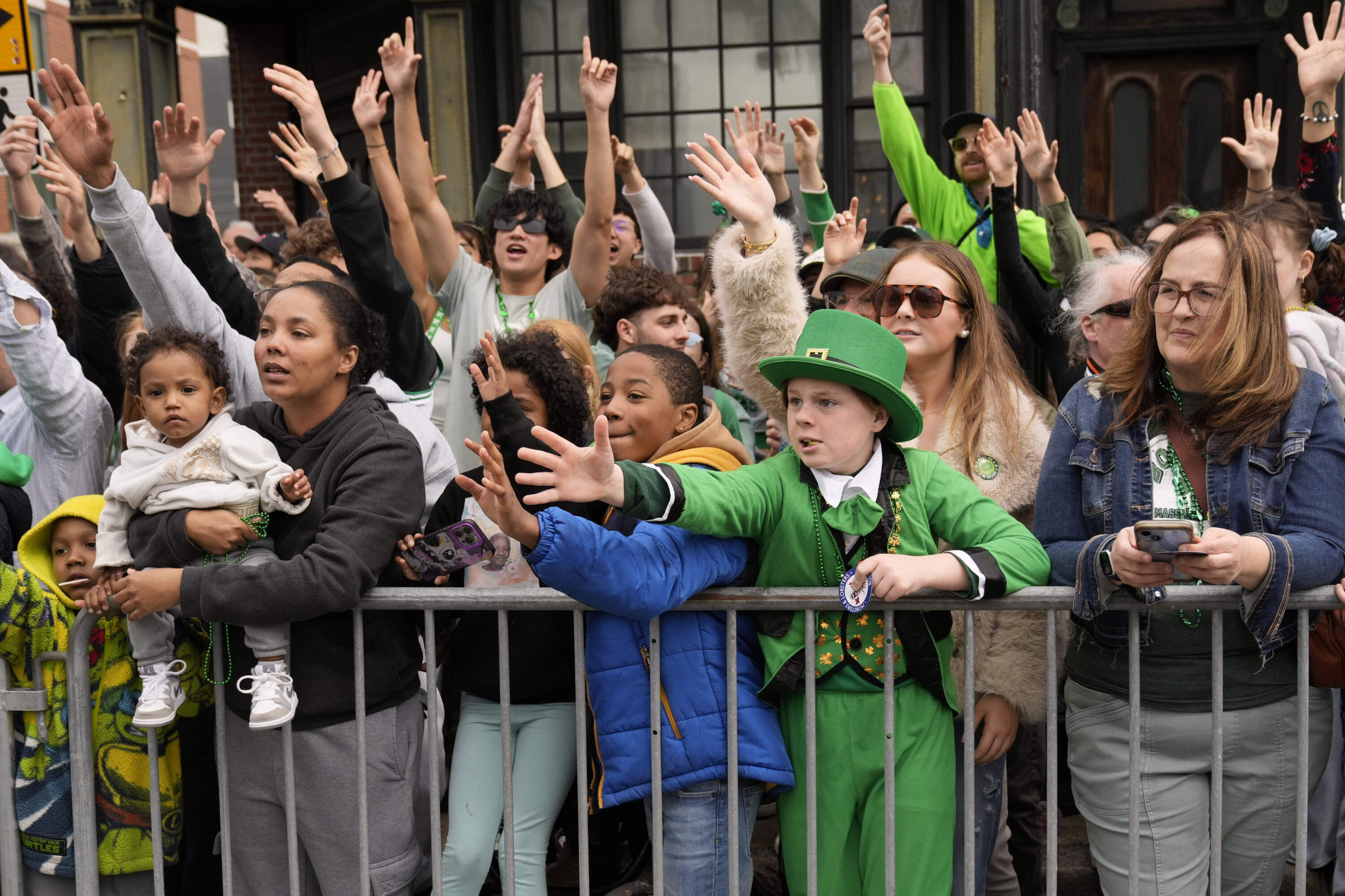Graham Johnston, of St. Louis, Mo., dressed as a leprechaun, and others reach for treats thrown by participants at the St. Patrick's Day parade. (Robert F. Bukaty/AP)