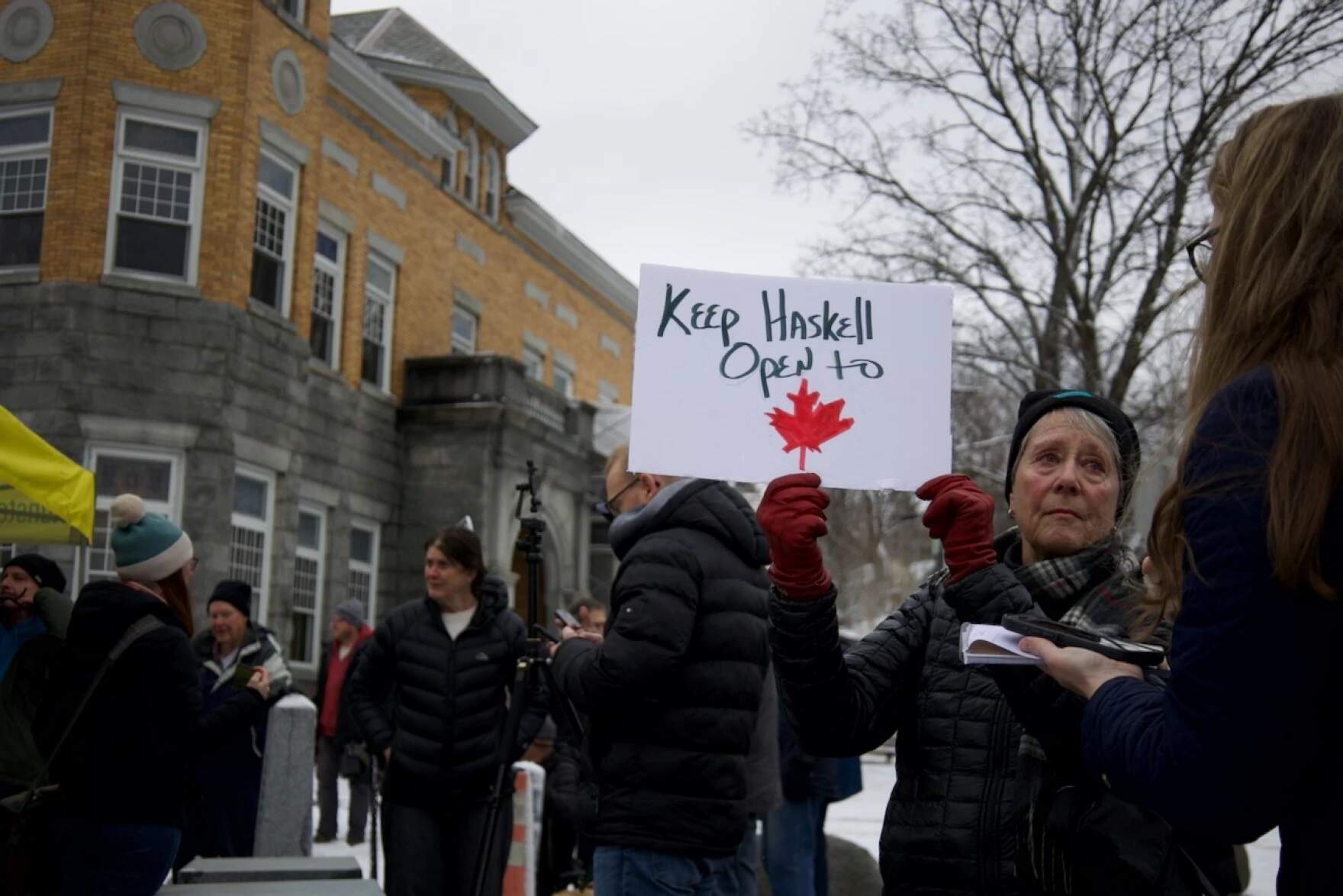 Penny Thomas of Newport protests a U.S. plan to restrict access to the Haskell Library, which straddles Stanstead, Quebec, and Derby Line, Vermont, on Friday, March 21. (Catherine Morrissey/Vermont Public)