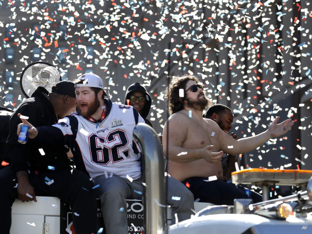New England Patriots' Joe Thuney (62) and David Andrews react to fans during a victory parade in downtown Boston in this 2019 file photo. (Elise Amendola/AP)