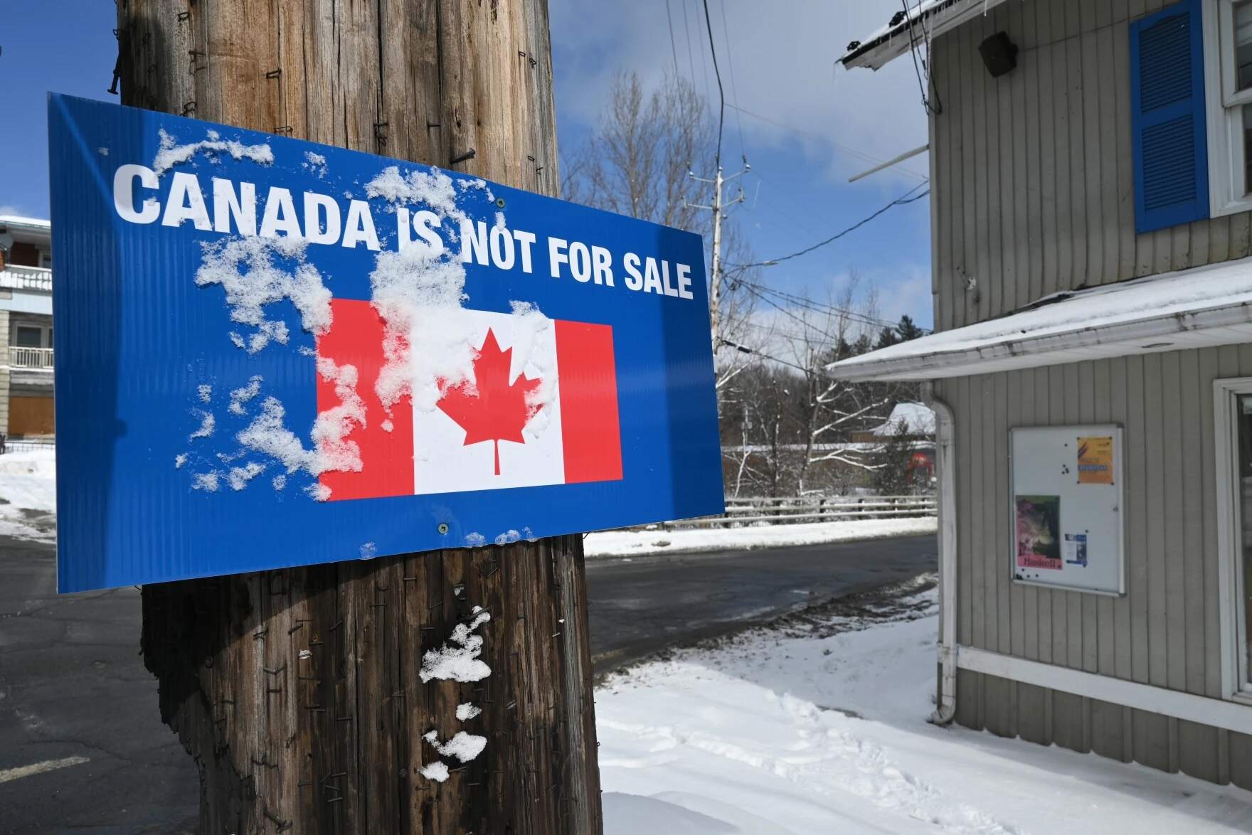 A sign that says "Canada is not for sale" is nailed to a pole in Stanstead, Quebec, a block from the U.S.-Canada border crossing, on Friday, Feb. 28, 2025. (Zoe McDonald/Vermont Public)